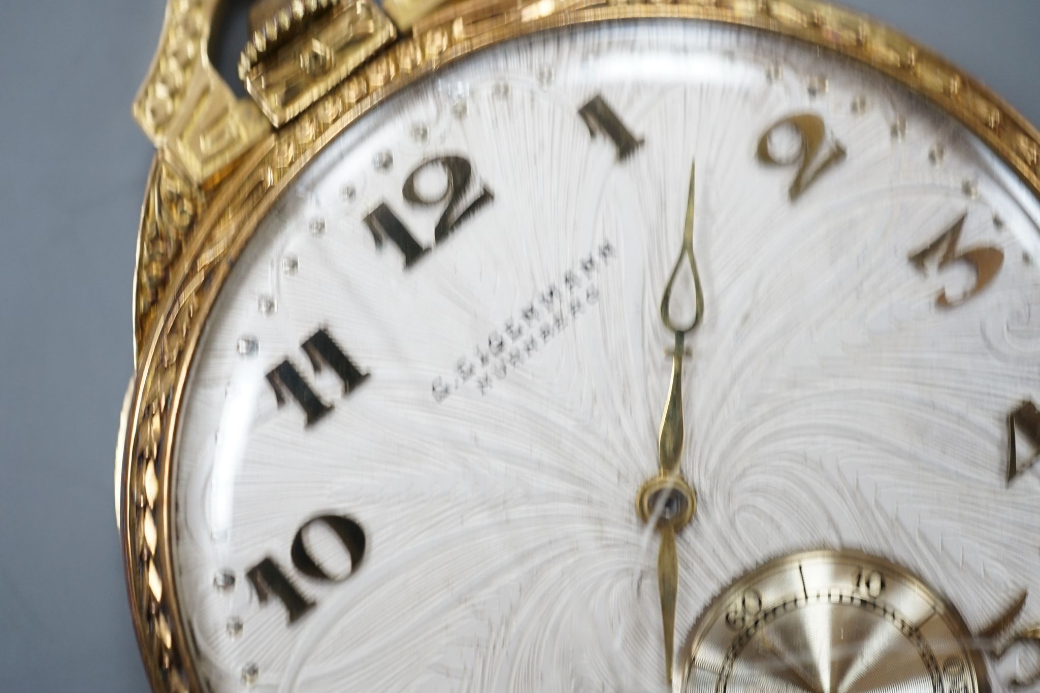 A continental engine turned 750 yellow metal open face dress pocket watch, retailed by Eigenmann, Nuremburg